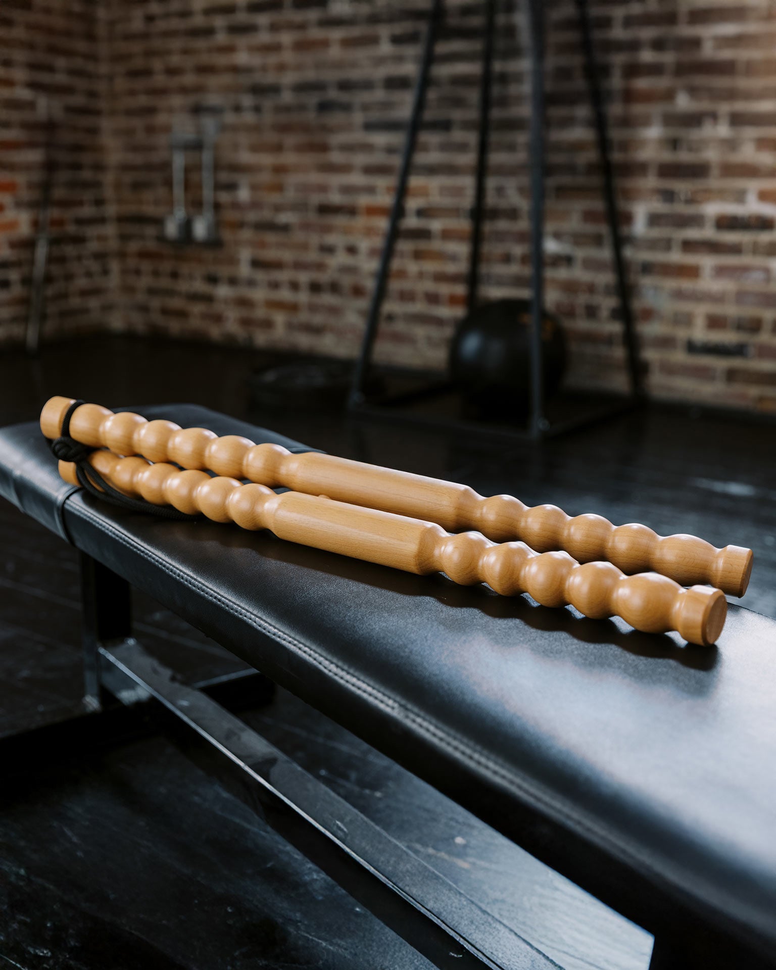 Wooden roller sticks on a black surface with a brick wall background
