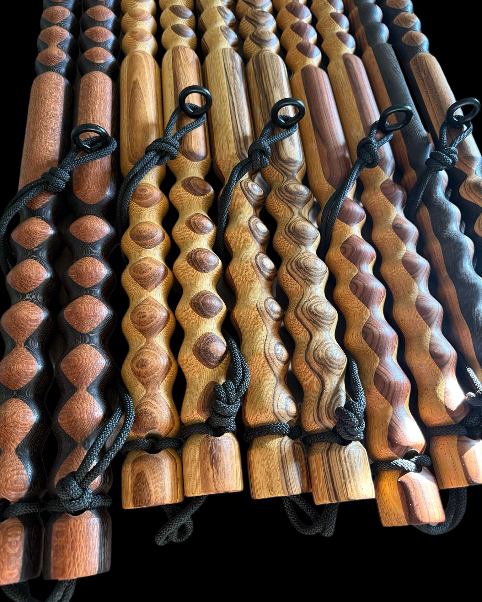 Five Custom Body Lever massage tools side by side in different wood color finishes