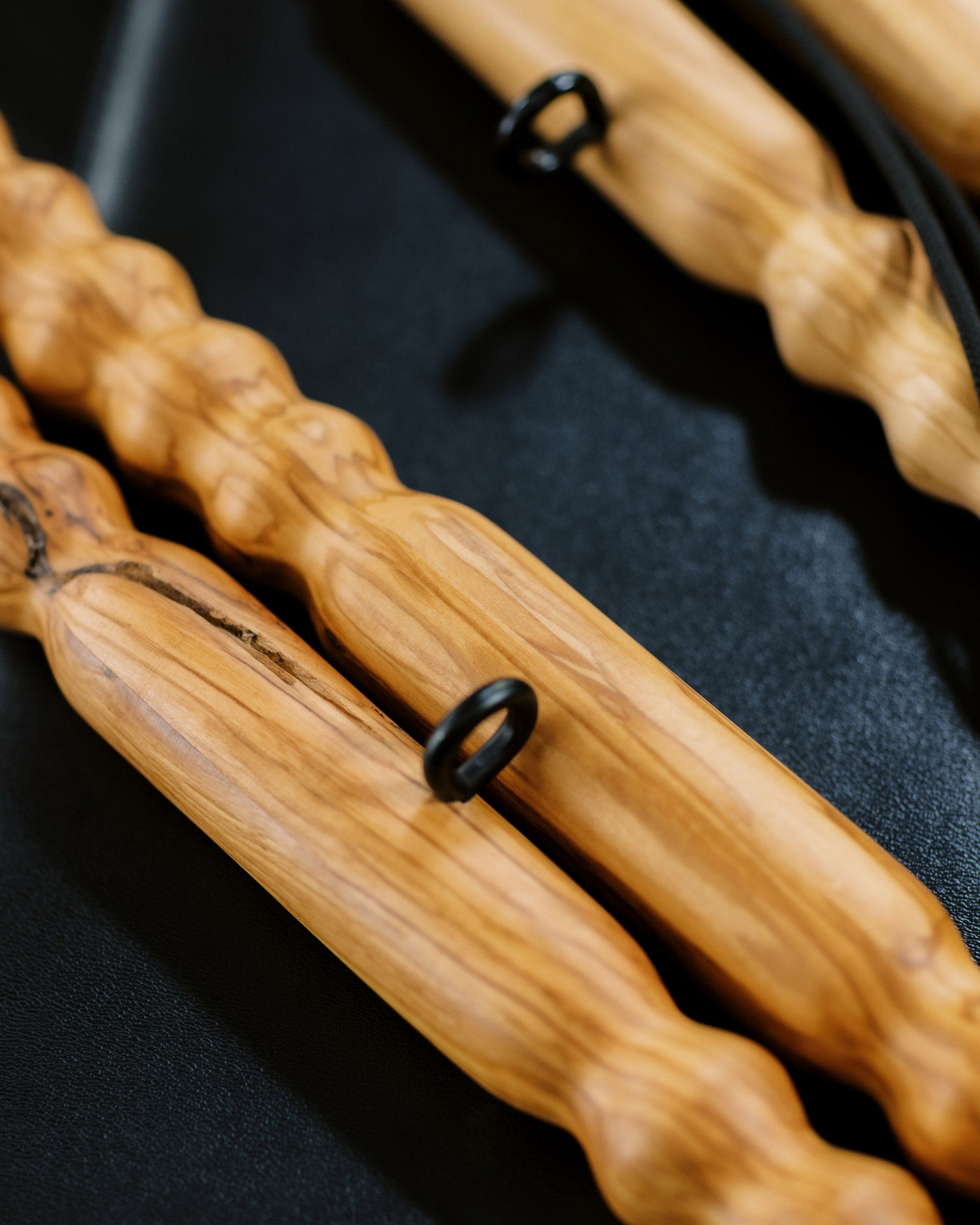 Up close detail view of wooden muscle massage tools highlighting the black metal notch